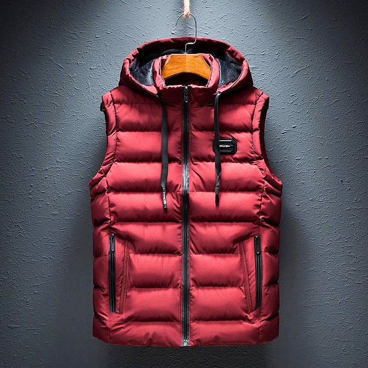 Men's black hooded puffer vest with zippered pockets for warm, versatile everyday comfort. Ideal casual outerwear.