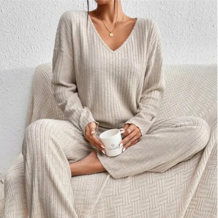 Woman models cozy ribbed knit two-piece loungewear set. Stylish & comfortable outfit for relaxing at home or casual wear.