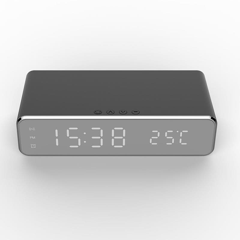 Digital LED alarm clock with a phone charging pad, showing a smartphone wirelessly charging on a gray unit.