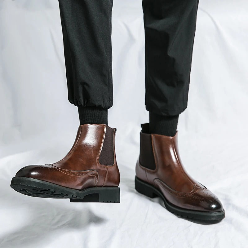 Close-up of the intricate brogue detailing on men's classic chelsea dress boots.