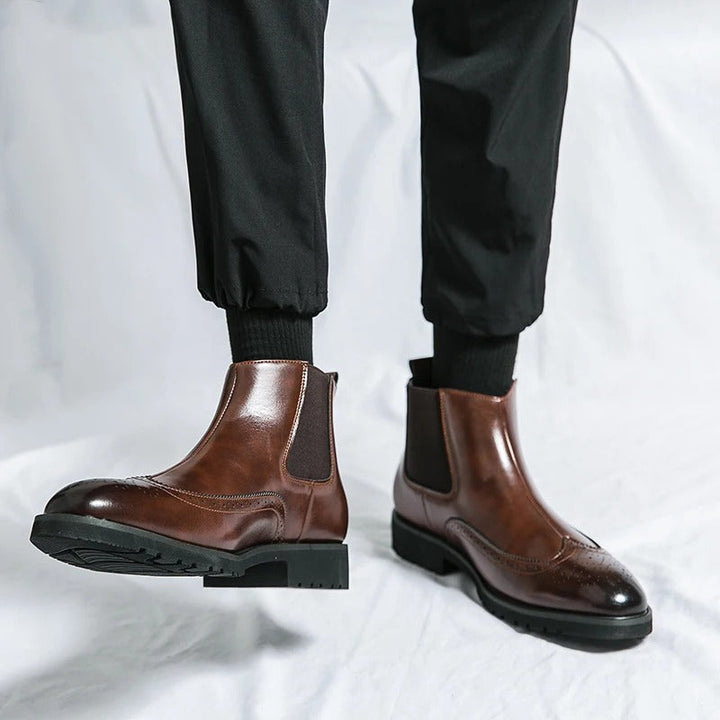Close-up of the intricate brogue detailing on men's classic chelsea dress boots.