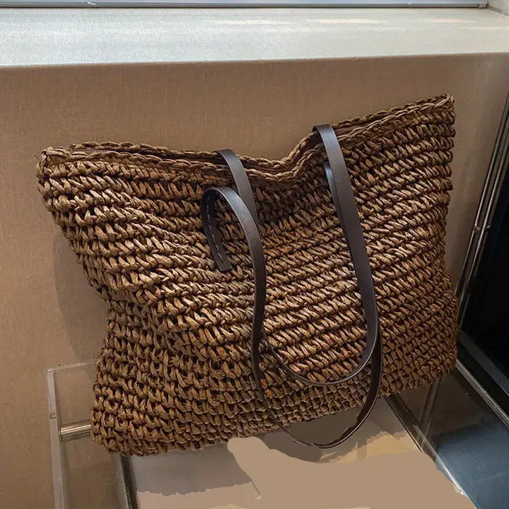 Fashionable women's oversized straw beach bag, an essential summer style accessory for vacations.