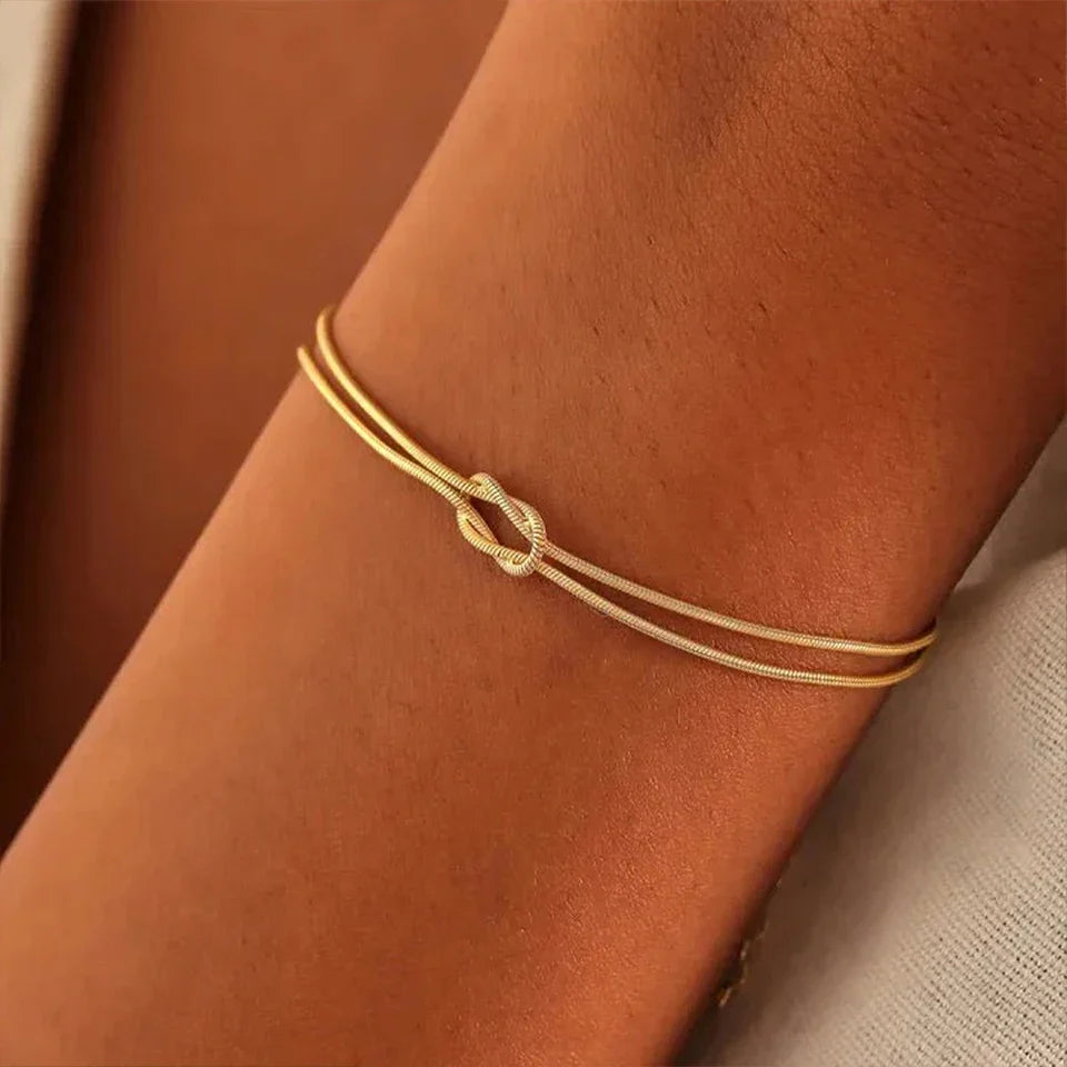 Close-up of the intricate Endless Knot design on a sleek stainless steel bracelet. Minimalist jewelry.