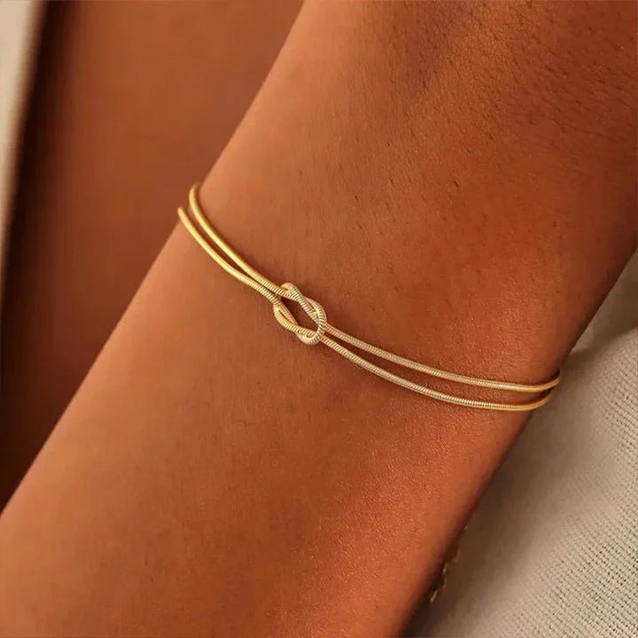 Close-up of the intricate Endless Knot design on a sleek stainless steel bracelet. Minimalist jewelry.