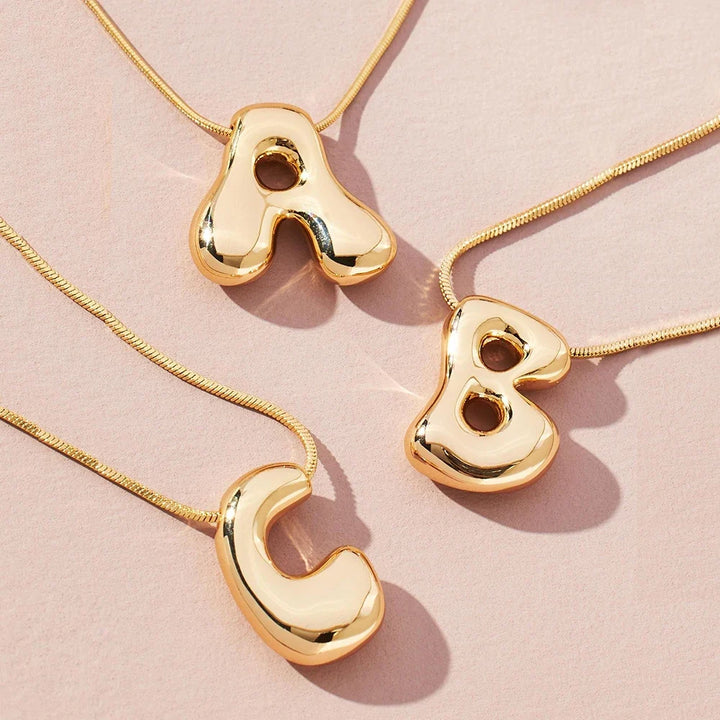 Personalized women's gold-tone initial letter pendant necklace. Elegant statement jewelry & fashion accessory.