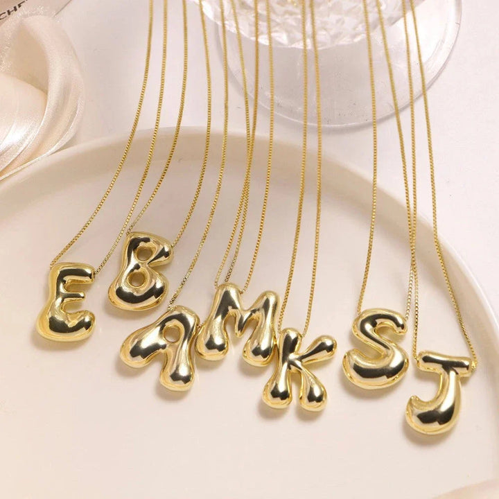 Women's golden initial letter necklace. Perfect personalized fashion accessory for elegant everyday wear.