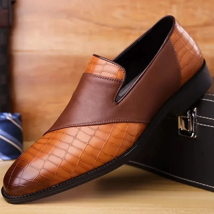 Tan leather men's slip-on loafers, showcasing premium material & classic stitching detail.