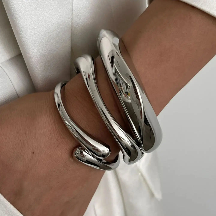 Stylish women's vintage stackable bracelets. A set of gold and silver accessories with elegant sculptural details.