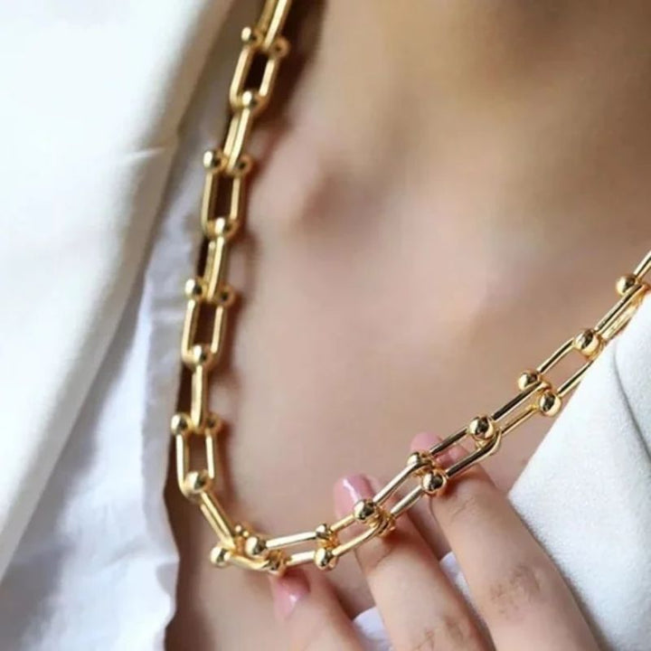 Women's elegant golden polished link chain necklace, a timeless fashion accessory.