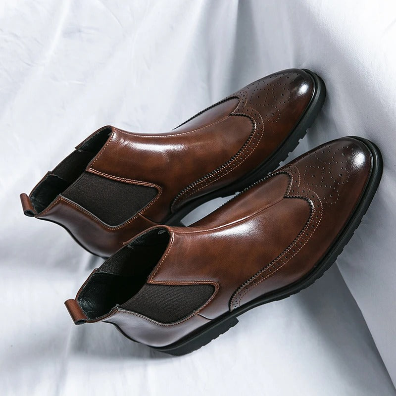 Stylish men's slip-on chelsea boots, featuring intricate brogue accents for a timeless look.