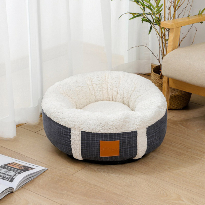 Small pet bed, round and plush, designed for cats and small dogs to offer comfort.