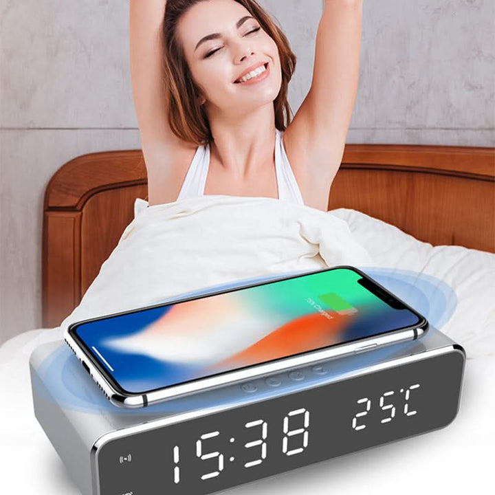 Sleek black digital alarm clock with bright LED display & integrated wireless phone charging pad.