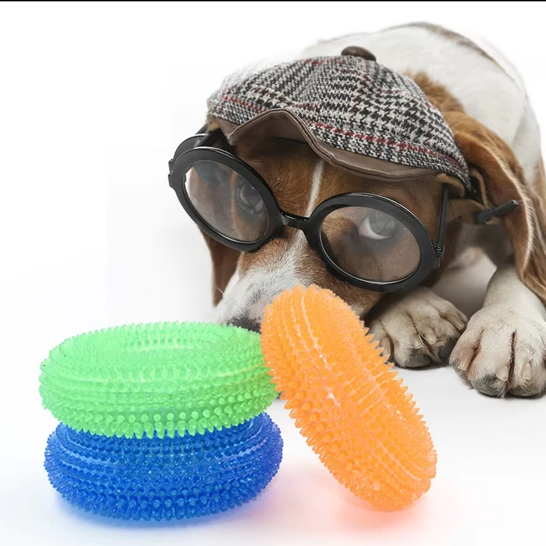 Dog chewing green teething ring, aiding dental care and plaque removal for puppies