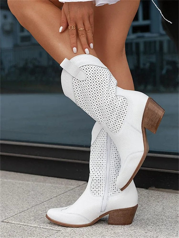 Modern women's western fashion boots with side-zip entry, supportive block heel, & intricate perforated design.