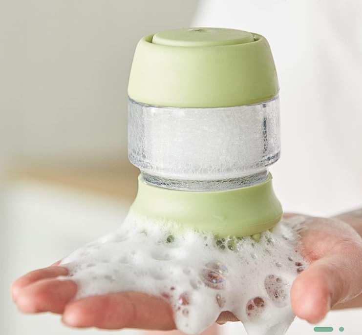 Close-up of pet shower bath brush bristles and shampoo dispenser button for pet massage