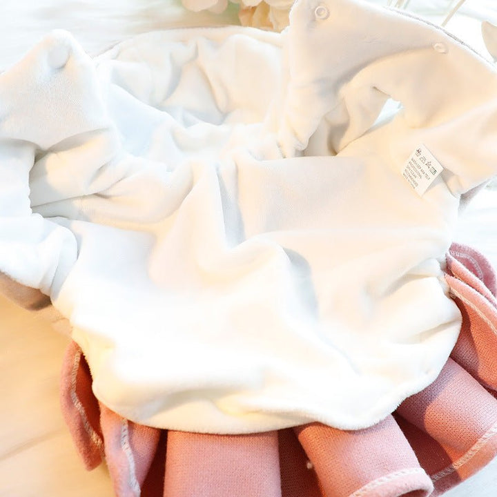 Detailed image of the soft pink fleece fabric and bow on a dog dress jacket for small pets