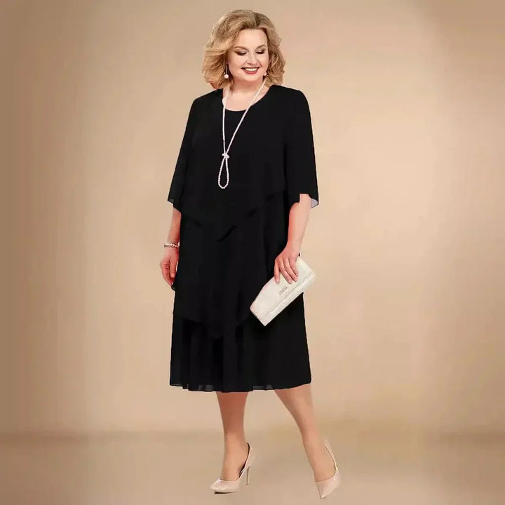 Elegant women's plus size purple chiffon layered knee-length dress with 3/4 sleeves, perfect for formal events.