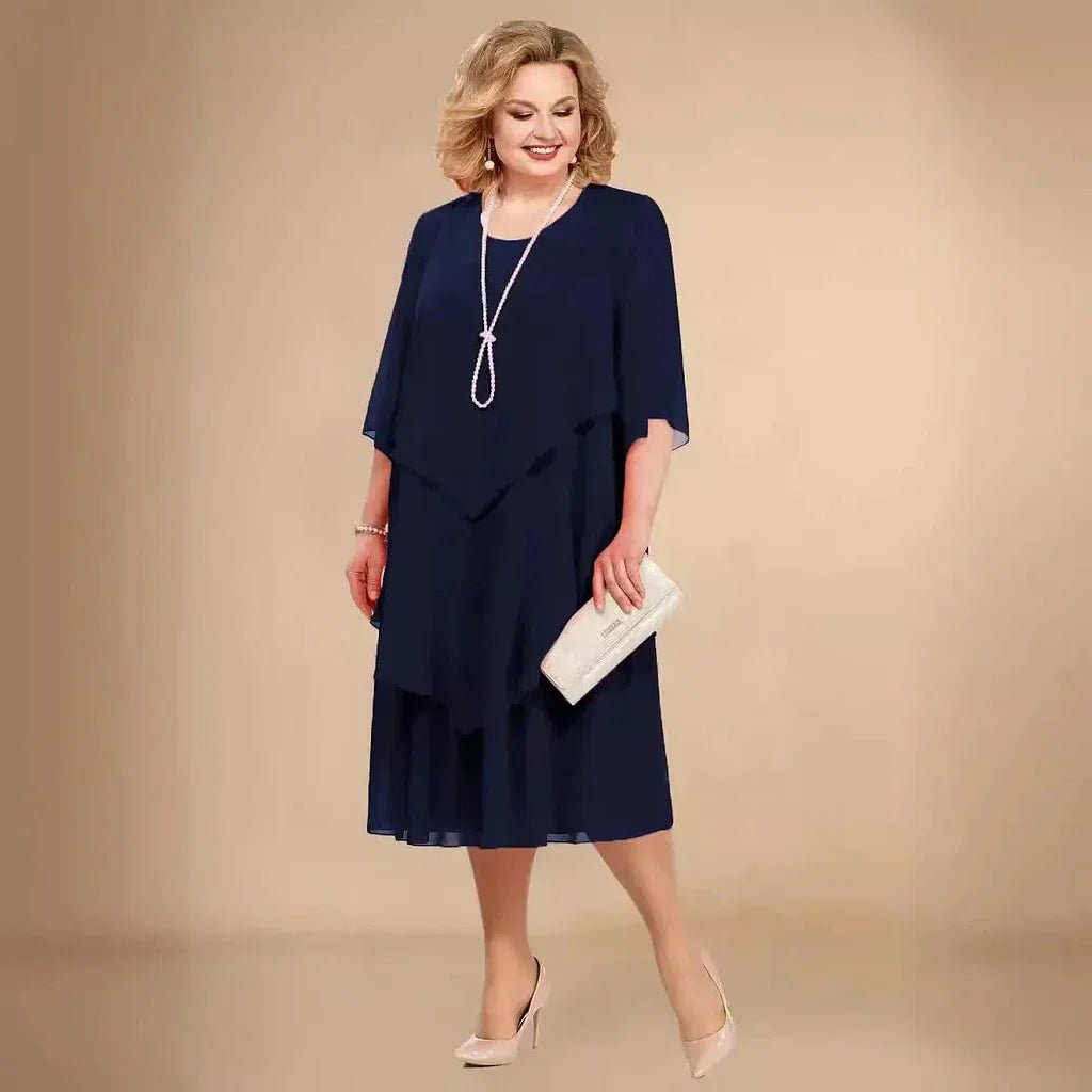 Stylish plus size purple chiffon cocktail dress for wedding guests, with elegant layers & three-quarter sleeves.