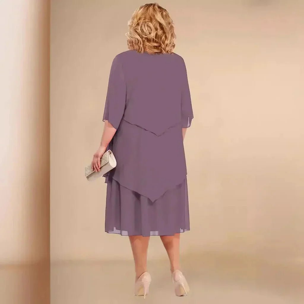 Full length view of a comfortable plus size purple knee-length chiffon dress, featuring elegant layers & 3/4 sleeves.