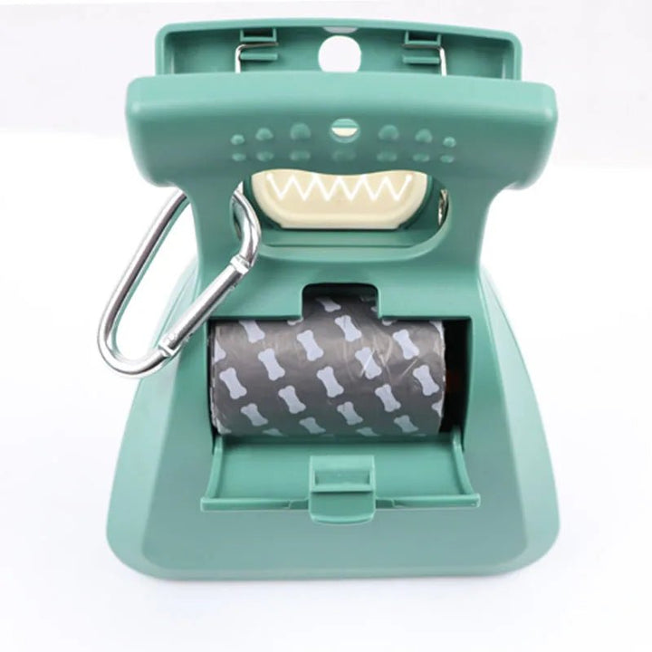 Portable dog scooper for pet waste, shown folded with a roll of biodegradable bags for cleanup