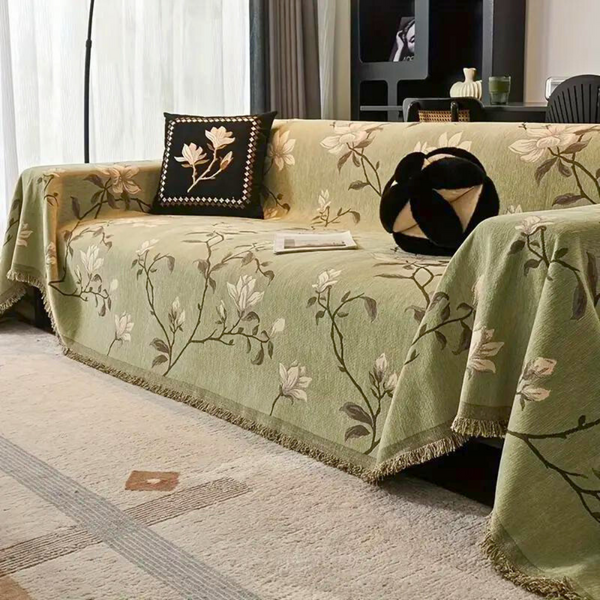 Vintage floral chenille sofa cover with elegant tassel trim, protecting living room furniture.