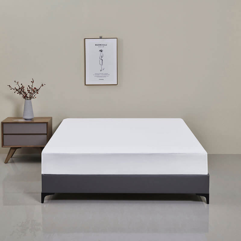 Bedroom scene with a bed featuring a neatly made waterproof fitted sheet, cozy and protected.