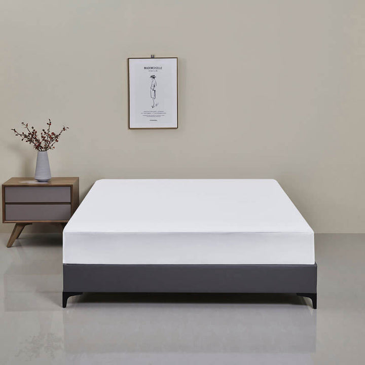 Bedroom scene with a bed featuring a neatly made waterproof fitted sheet, cozy and protected.