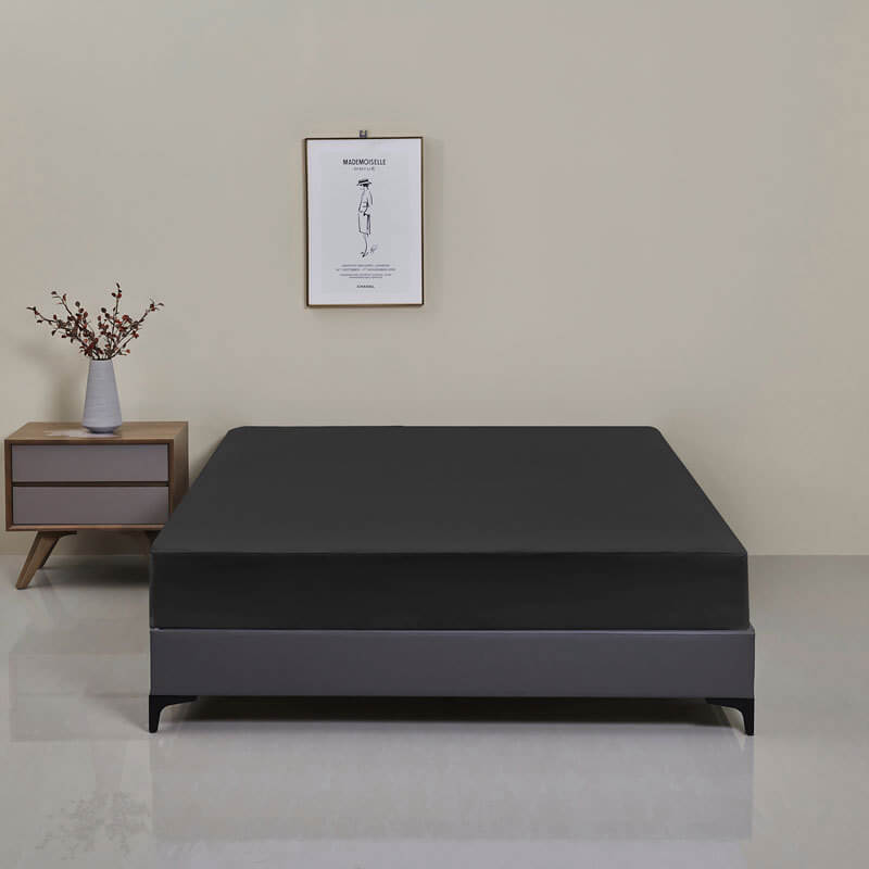 Detail of the elasticized edge of the waterproof fitted sheet, ensuring a secure, mattress-hugging fit.