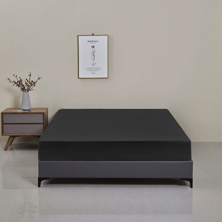 Detail of the elasticized edge of the waterproof fitted sheet, ensuring a secure, mattress-hugging fit.