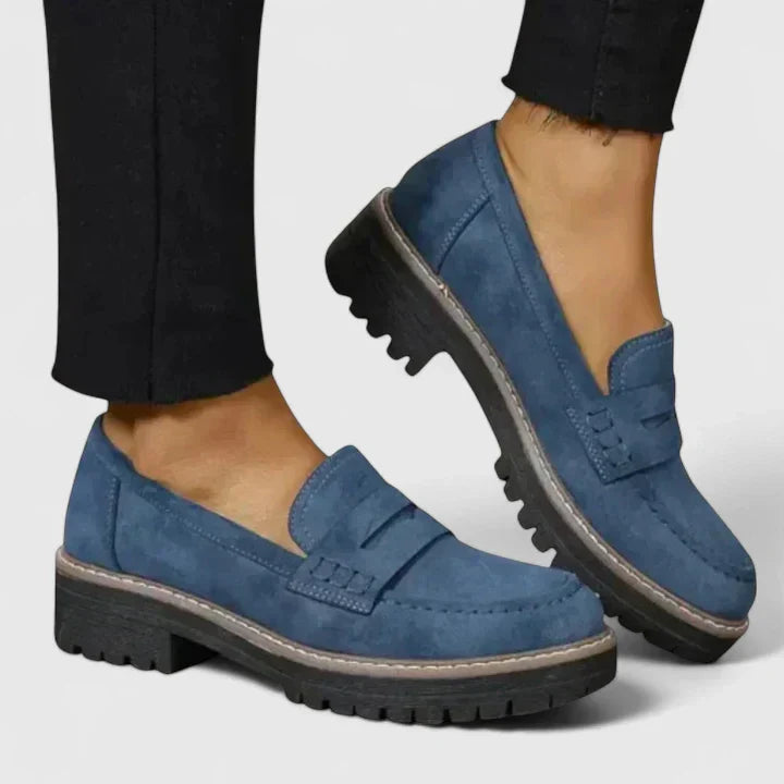 Close-up of black women's chunky penny loafers, featuring a comfortable lug sole for modern fashion.