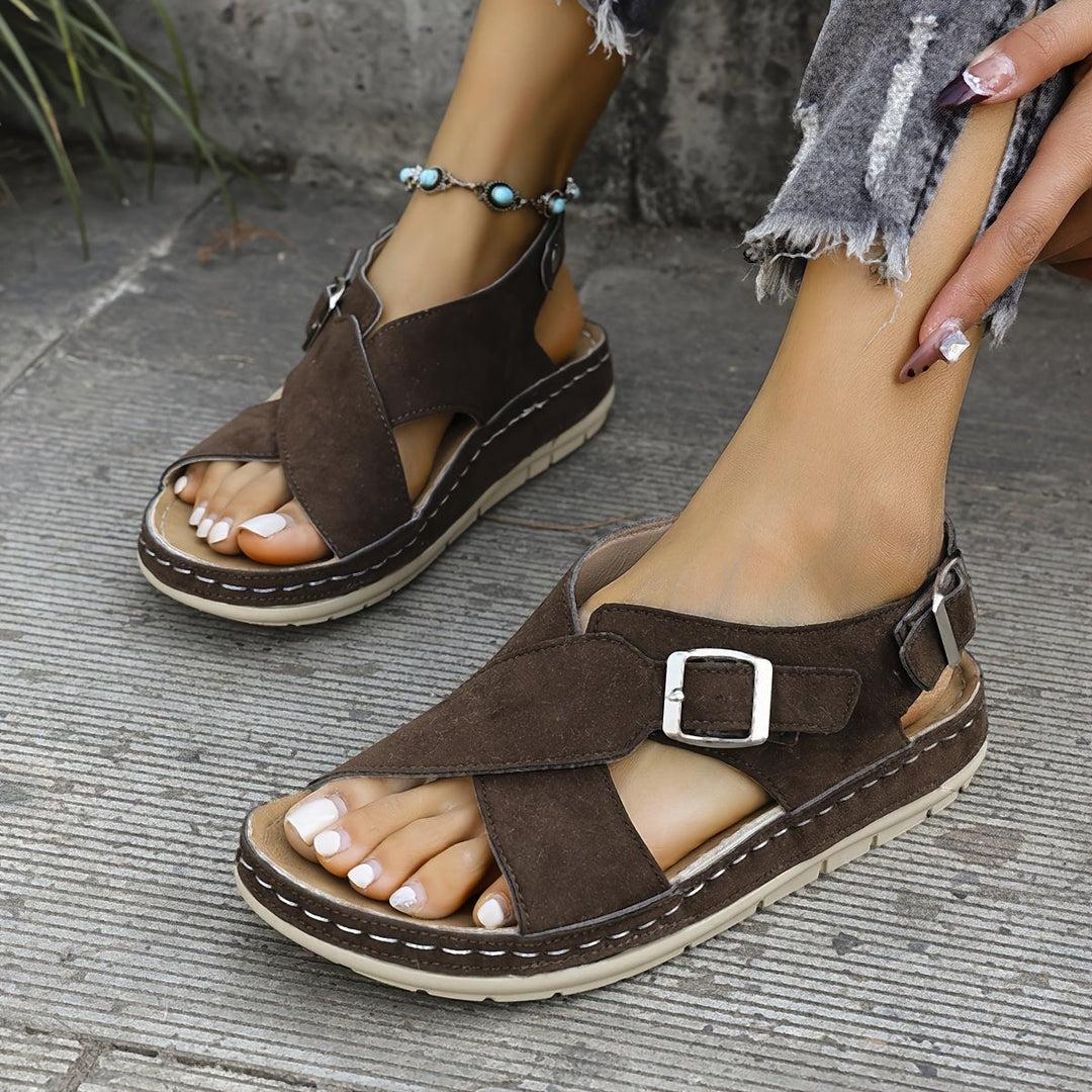 Walking-friendly women's cross-strap sandals with a cushioned platform for comfort.