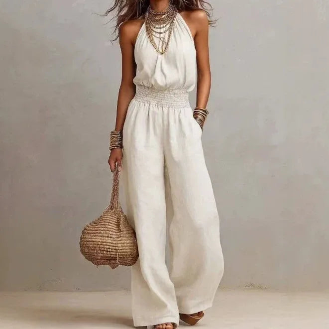 Women's halter neck wide leg jumpsuit with a smocked waist & pockets. Comfortable & stylish for summer.