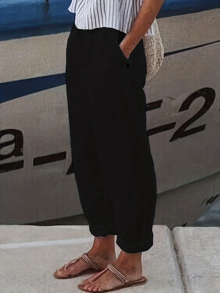 Relaxed fit women's high waist pants featuring an elastic waist, practical pockets, and chic roll hem.